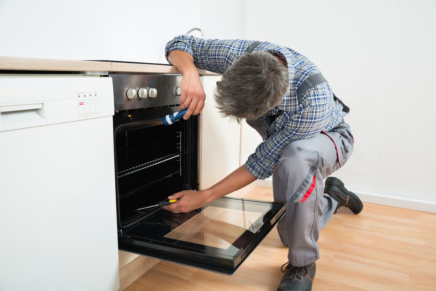 Oven Repairman In Chesterfield Inspecting A Cooker